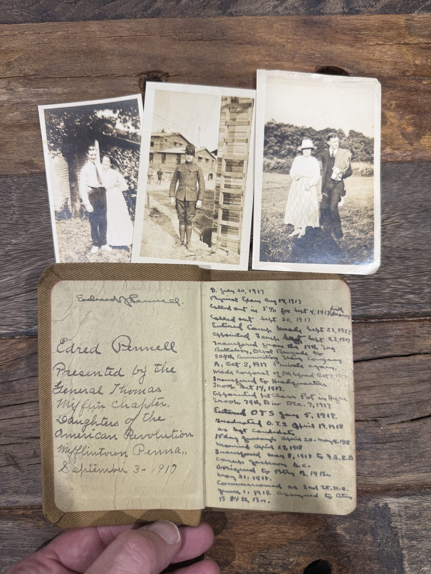 The Testament open to Edred Pennell's inscription and service record, beside the photographs he kept inside.